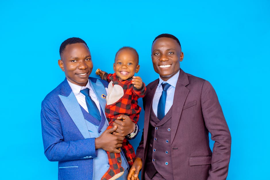 Father, son, and friend in suits and smiles against a vibrant blue backdrop.