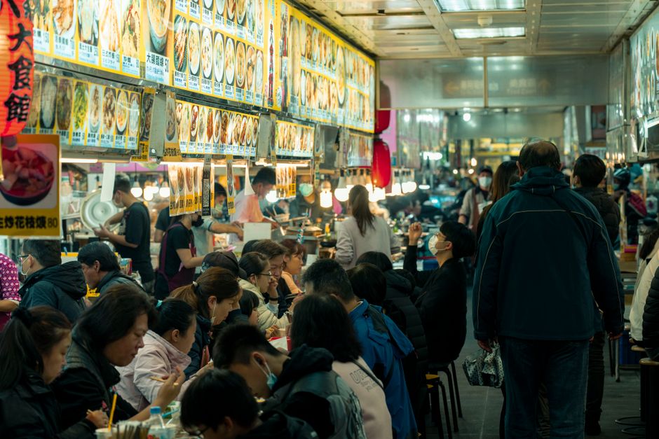 Lively food court scene showcasing a bustling crowd enjoying diverse Asian cuisine.