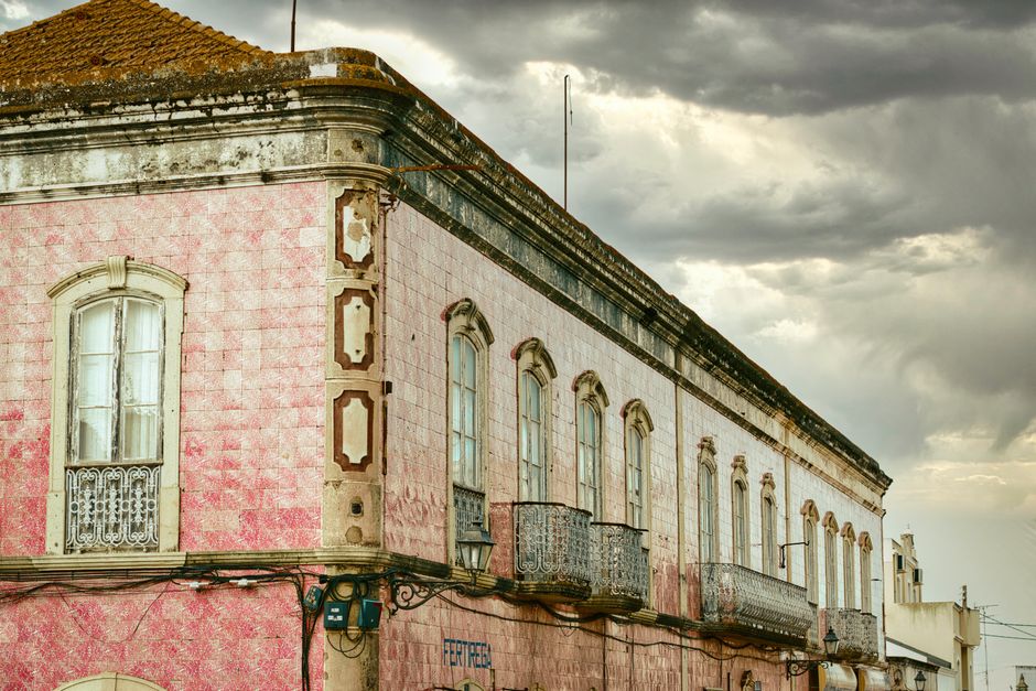 Photograph of a historic European building with ornate ceramic tiles under an overcast sky.