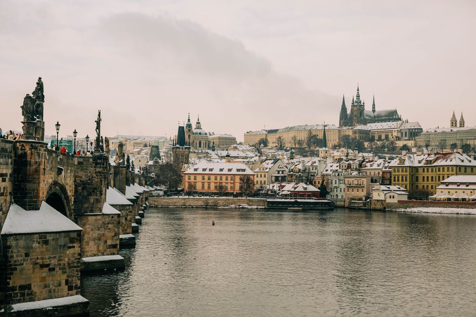Historic Charles Bridge and snowy Prague Castle during wintertime in Prague.