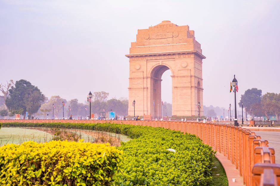 A vibrant capture of the iconic India Gate in New Delhi, surrounded by lush gardens on a sunny day, showcasing its architectural brilliance.