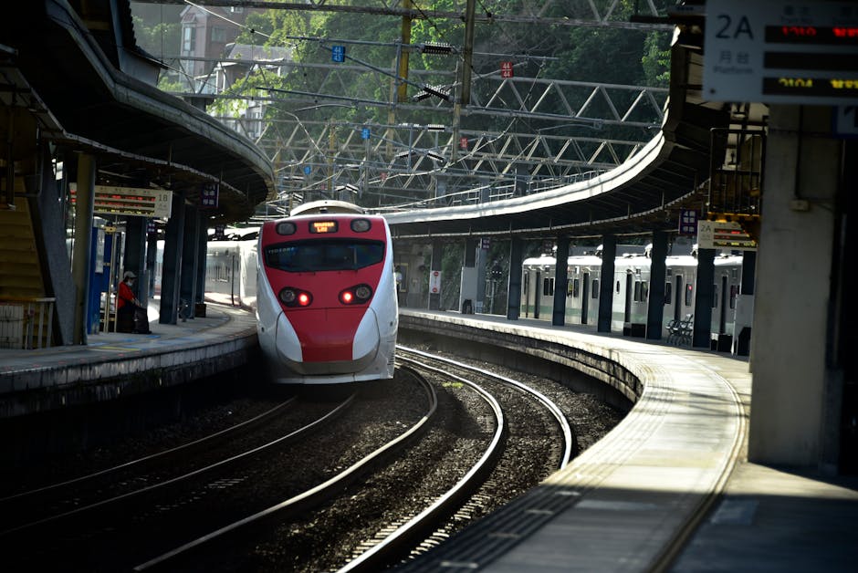 A dynamic shot of a high-speed train arriving at a busy urban station, capturing motion and architecture.