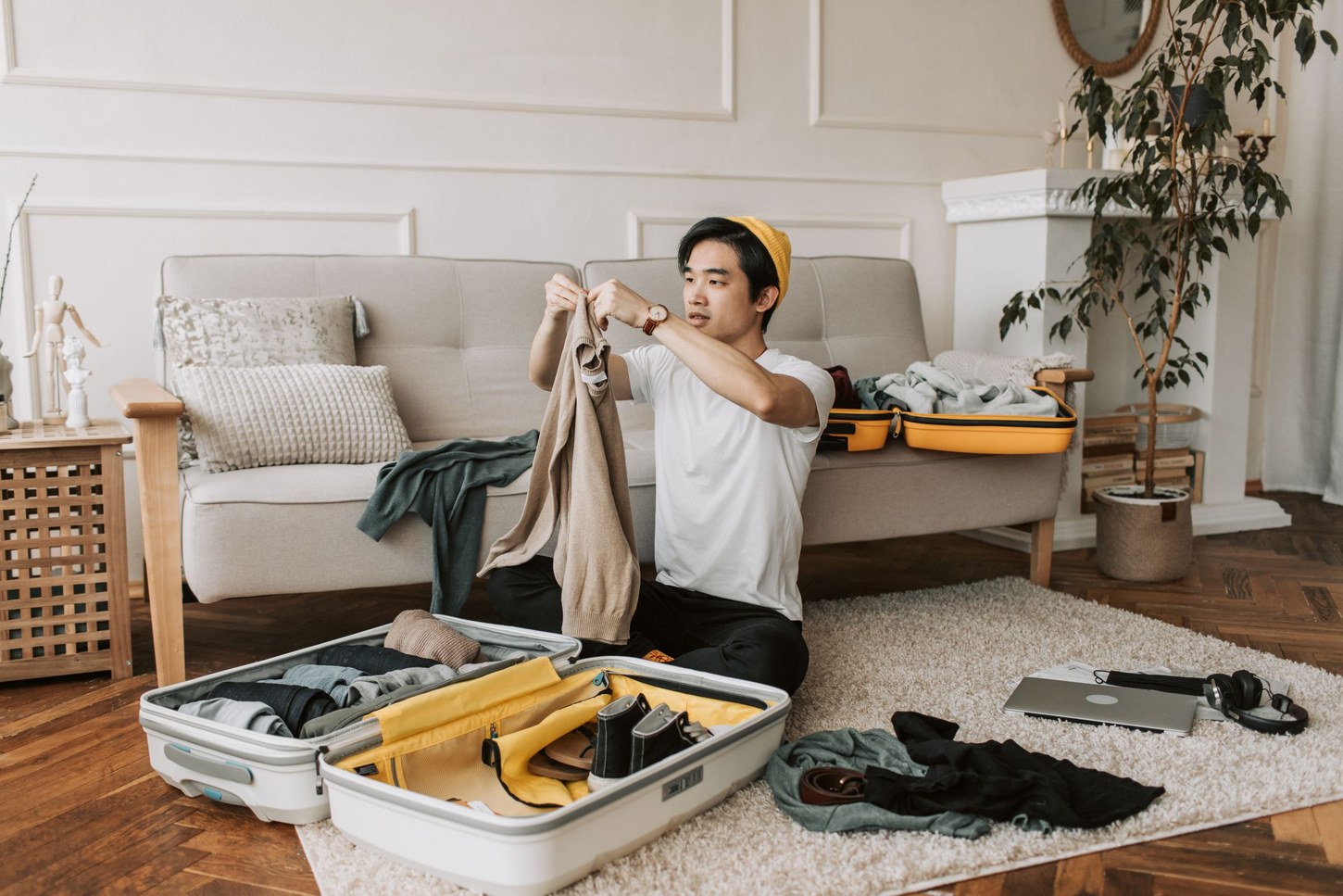 Traveler packing clothes into an open suitcase at home