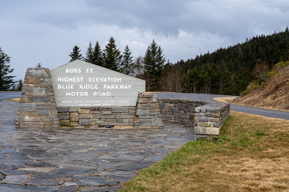 Blue Ridge Parkway sign at 6053 ft, highest elevation; scenic mountain road in North Carolina.