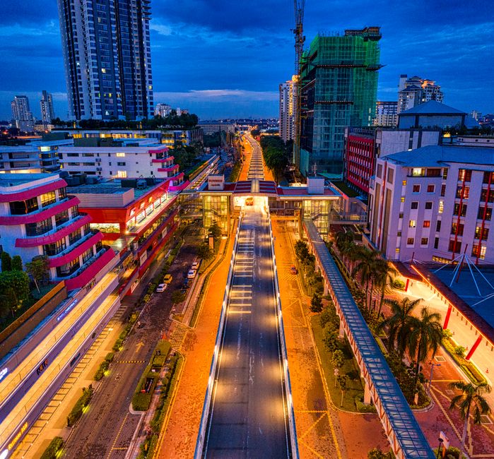 A vibrant aerial view of Subang Jaya, Malaysia at night with illuminated streets and urban architecture.